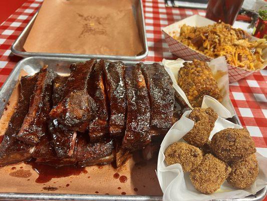 Ribs platter with hush puppies, fried corn, cheese fries in the back