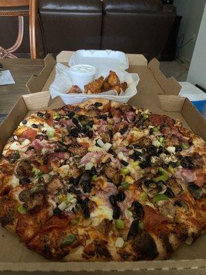 Super supreme pizza with wings.