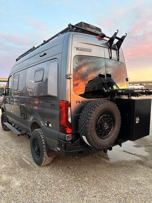 Winnebago Revel on a 144 wheelbase Sprinter with one-up bike trays, Aluminess rear swing bumper, and larger fuel tank.