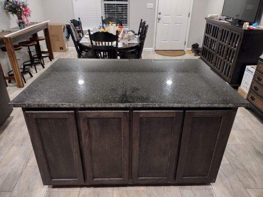 New kitchen island with black granite countertop.