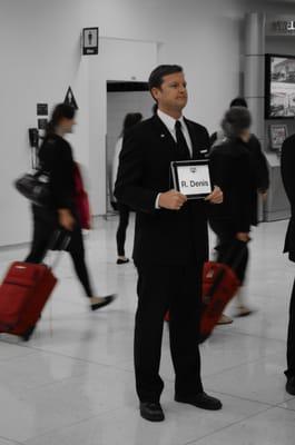 Senior Chauffeur Ian greeting clients at LAX with iPad