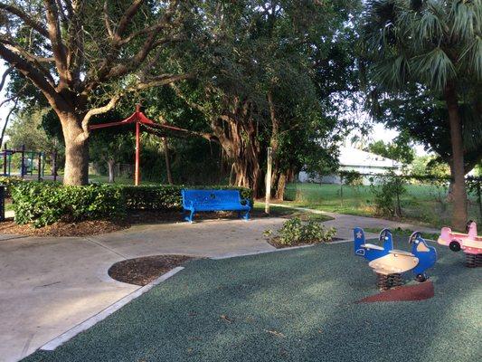 Very shady bench and mist sprayer in between playgrounds