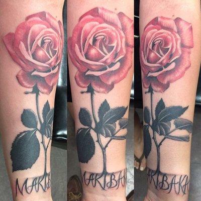 Forearm rose tattoo with "makibaka" on wrist as the rose roots.