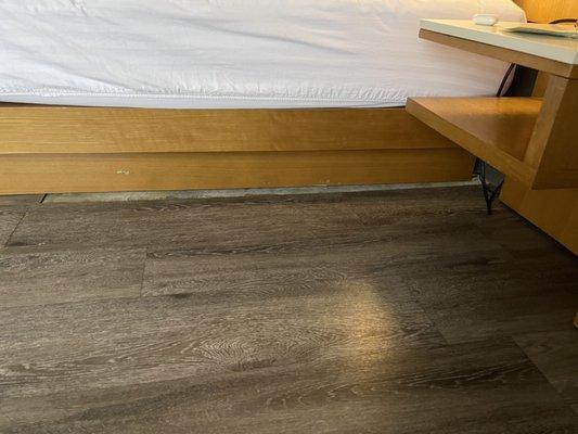 Exposed concrete on floor beside the bed.