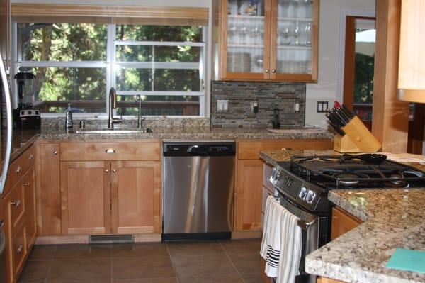 My kitchen with custom cabinets, granite countertops, a stone and glass back splash.