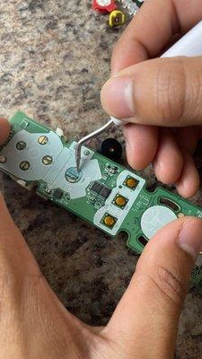 Removing battery corrosion from Wii remote traces and attempting restoration.