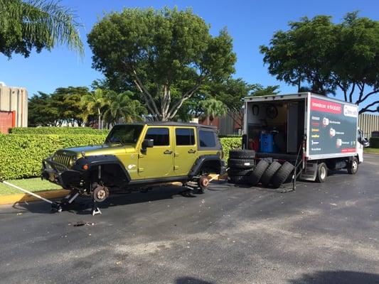 Jeep jacked up and tires ready to be changed