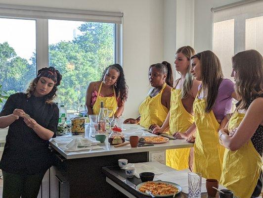 Chef Raina teaching Students how to fold dumplings at Did You Khado Kitchen