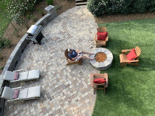 Concrete pavers, seating wall, artificial grass and fire pit.