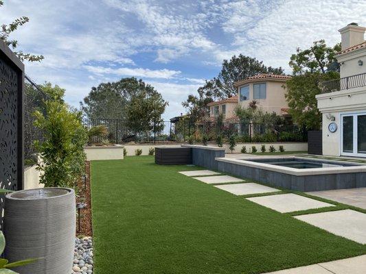 A new complete backyard with pool and spa, outdoor kitchen, BBQ island, fire place, fire pit, syn lawn, all designed by Landscape Logic