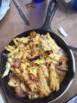 Pulled pork Mac n cheese baked with bacon, onions and topped with crumbled corn bread