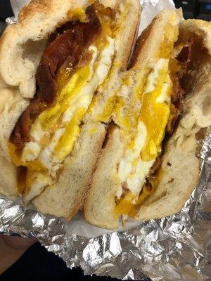 Well done bacon, over easy eggs and cheddar cheese on a lightly toasted roll with light butter