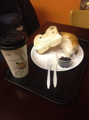 Coffee and plain bagel with crm cheese. Little grape jelly on the side