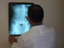 Dr. Chan is carefully reviewing and evaluating a patient's xray