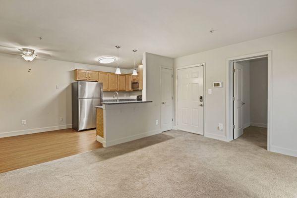 Updated kitchen with breakfast bar, pendant lighting, stainless steel appliances, and vinyl plank flooring.