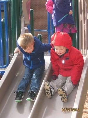 Sliding together on the playground.