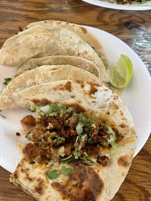 Pastor tacos on flour tortillas.