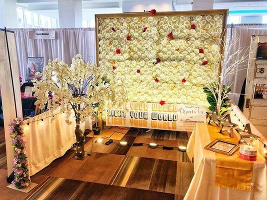 One of our flower walls and white cherry blossom tree that we rent on display in Albany during a bridal expo