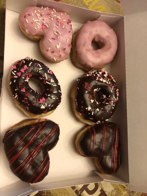 Donuts themed for St. Valentine's Day, half dozen. Strawberry/strawberry filled, chocolate + sprinkles, Boston Creme. (2/16/2018)