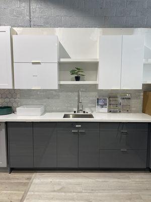 High Gloss kitchen Cabinet in white and grey. The white cabinets are paired with gold handles. The grey cabinets are paired with silver.