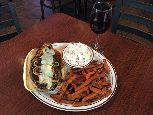 Prime rib sandwich served with sweet potato fries and cole slaw.