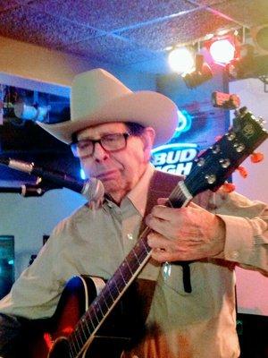 Al singing and playing in front of a live audience.