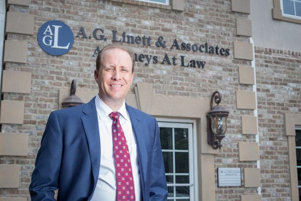 Adam G. Linett in front of the main building