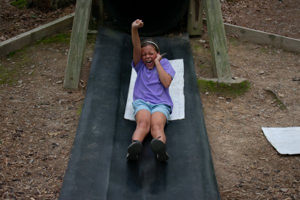 Camper sliding down the Shady Chute slide.