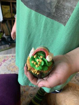 My son holding a st. Paddy's day cupcake with a rainbow and little gold coins