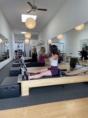 GBP instructor teaching a new exercise to a duet class. Students are focused and engaged, embracing the challenge in a relaxed studio vibe.