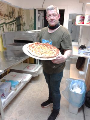 OWNER WITH FIRST PIZZA ON OPENING DAY