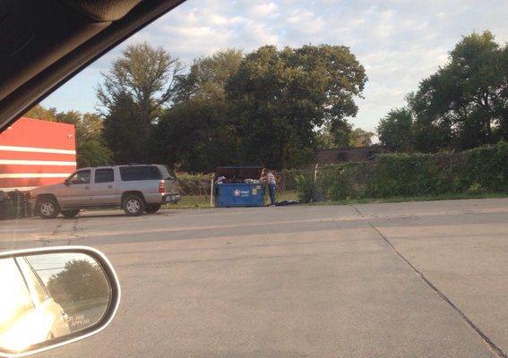 Homeless woman going for breakfast in dumpster at store