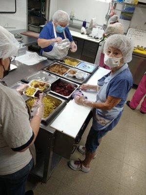 Volunteers hot packing meals.