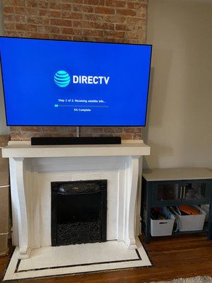 Tv mounted above brick fireplace with wires ran to nearest outlet using plastic wire concealers.