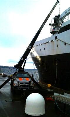 MPH boom truck lifting a winch onto a vessel