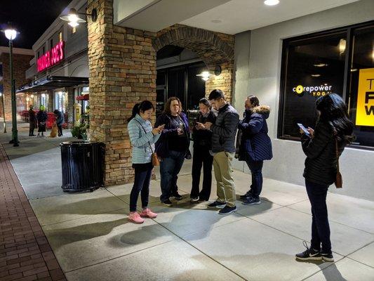 This is what a group of Zombie Scavengers looks like in Sandy Springs. A group of people standing on the sidewalk on their phones.