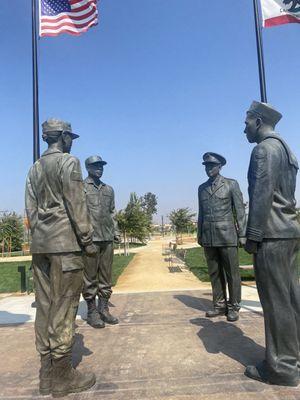 4 members of U. S. Armed Services facing each other.