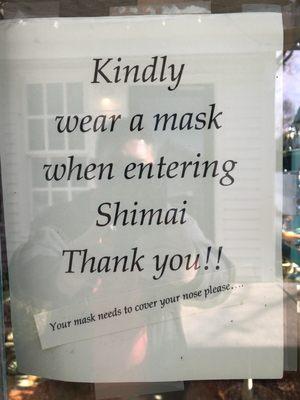 Sign on the door requests that customers wear a mask.