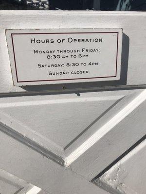 Hours of operation posted on door facing 26th Street