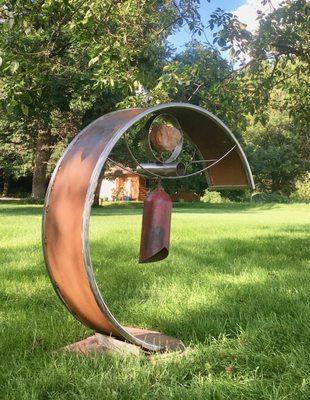 Kinetic sculpture with bell. Stainless steel, carbon steel, stone, reclaimed materials.