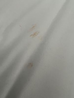 Orange Cheeto stain on sheets with someone's hair