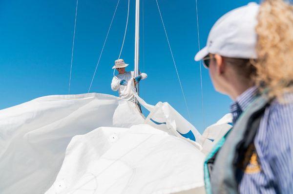 Our Director, Captain Card, demonstrating how to hoist a mainsail during a lesson and photo shoot with GoDaddy!