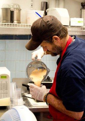 Volunteer Carson pouring a fresh fruit smoothie.