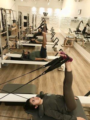 Reformer/chair class cooling down & stretching at the end of class.