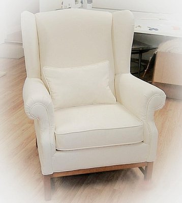 Wingback chair reupholstered in white denim.