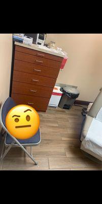 This chair seems out of place...and the exam chair(seen next to weird chair) is awfully close to the door. It's just a super tiny room.