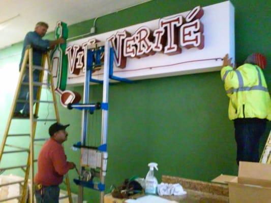 Construction, summer 2015.  Putting up the old sign inside behind the tasting bar.