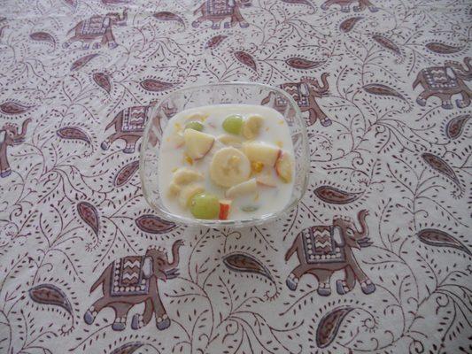 Banana Apples Green grapes and milk fruit salad