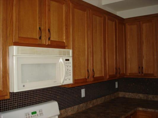 Oak cabinets with glass  tiled back splash