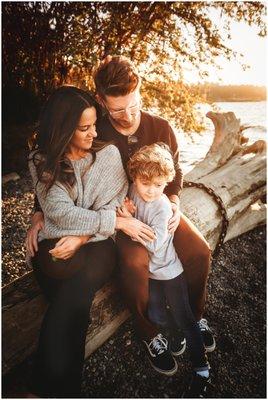 Family of three on beach at sunset